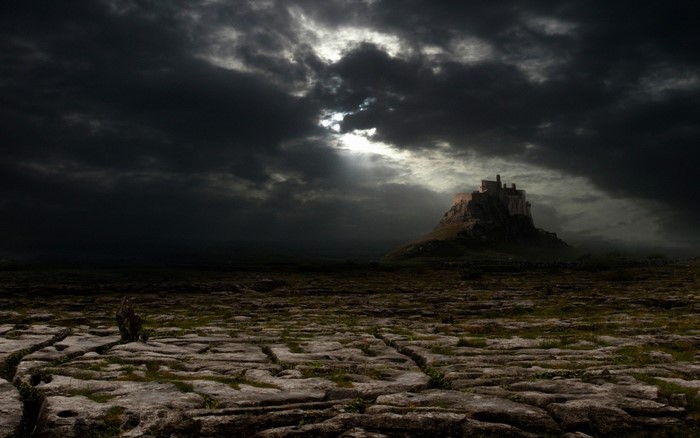 Castle on a rocky hill under stormy clouds