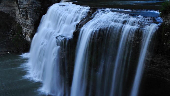 Waterfall cascading over rocky cliffs into a body of water