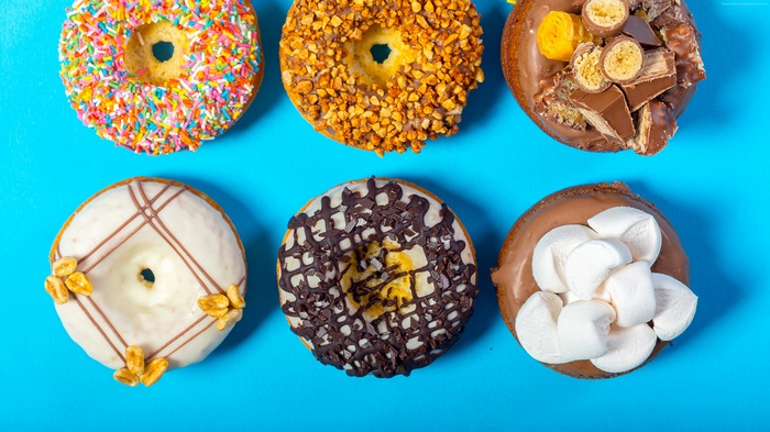 Six assorted donuts on a blue background