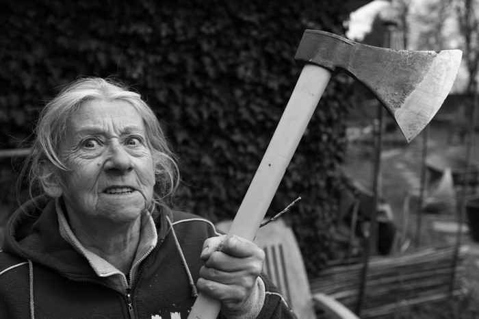 Elderly woman holding an axe