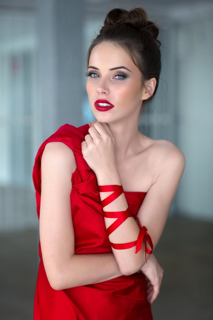 Woman in red dress with red ribbon on arm