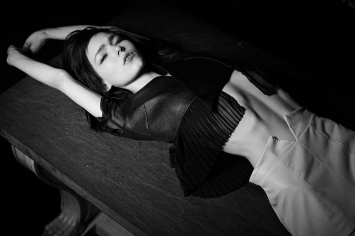 Monochrome portrait of a woman lying on a table