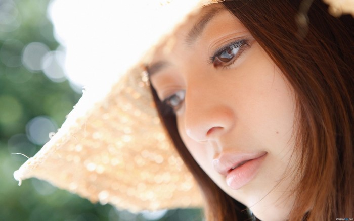 Close-up portrait of a young Asian woman wearing a straw hat