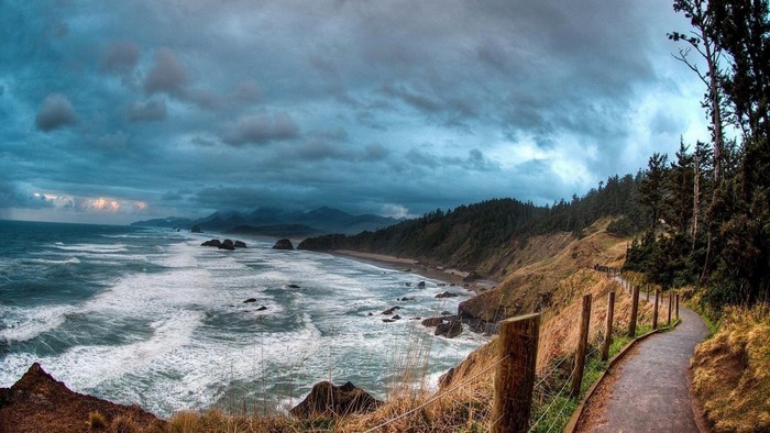 Coastal path overlooking the ocean with stormy clouds