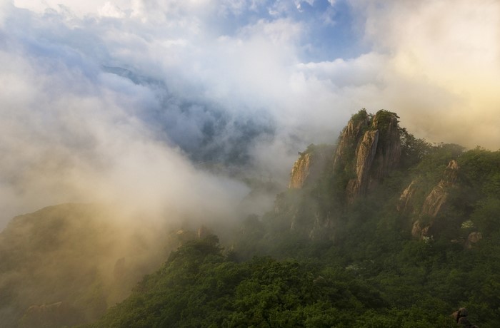 Misty mountain ridge with sunlight and clouds