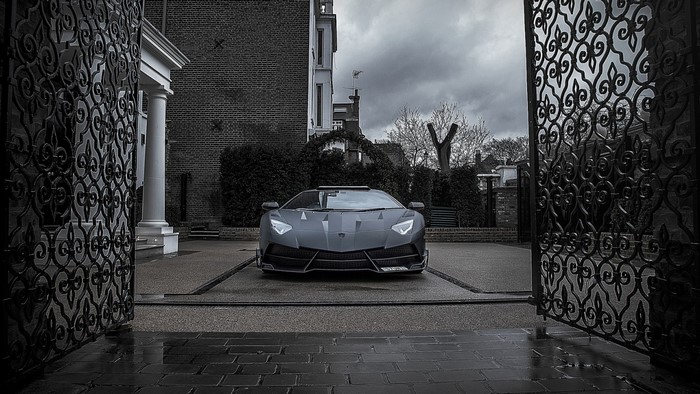 Lamborghini Aventador parked in front of a building with gates
