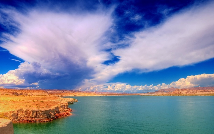 Desert landscape with a large body of water and dramatic clouds