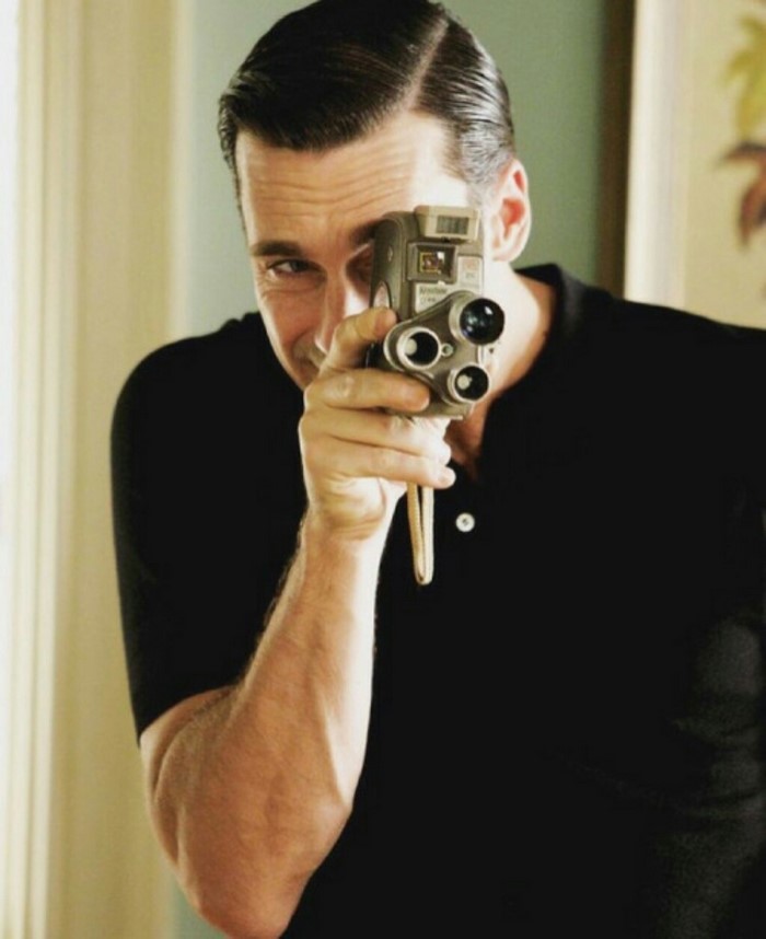 Jon Hamm holding a vintage movie camera