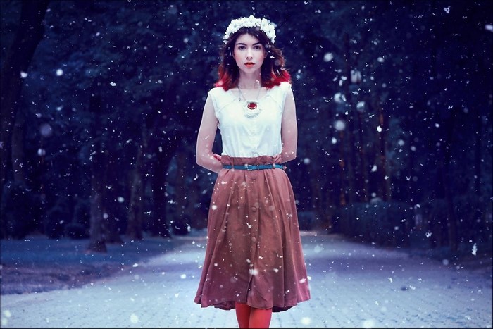 Woman with flower crown in falling snow