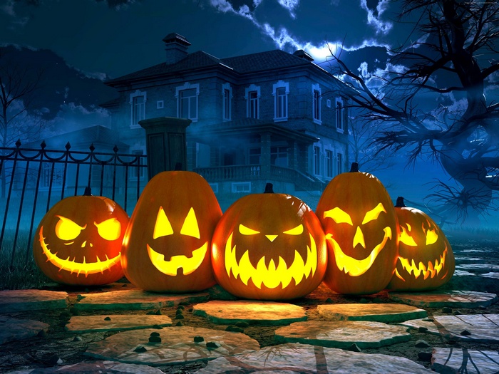 Halloween pumpkins in front of a haunted house