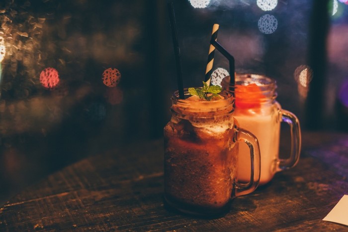 Two mason jar drinks with straws and mint