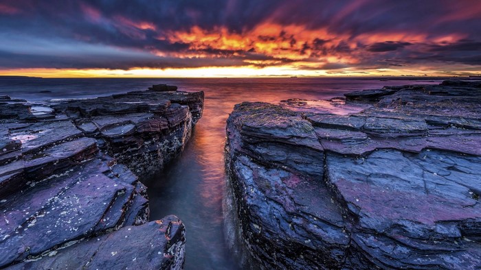 Dramatic Sunset Over Rocky Coastal Bay