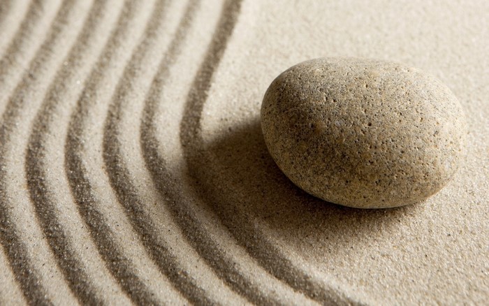 Zen garden with raked sand and a single stone