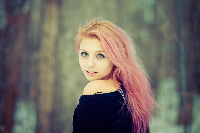 Woman with pink dyed hair looking over her shoulder