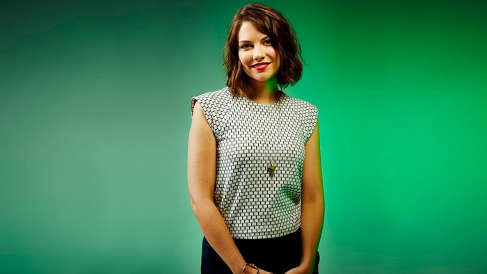 Lauren Cohan posing against a green background