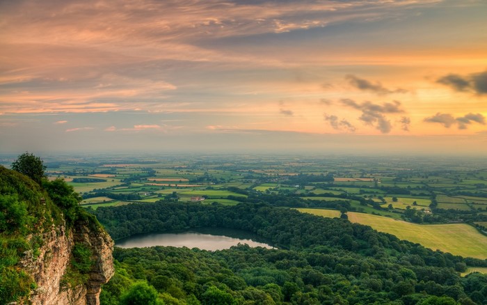 Sunset over a rural landscape with a lake and cliffs