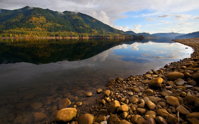 Mountain lake with reflection and rocky shore