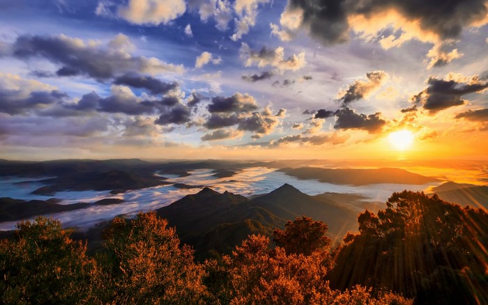 Sunrise over misty mountains with sun rays