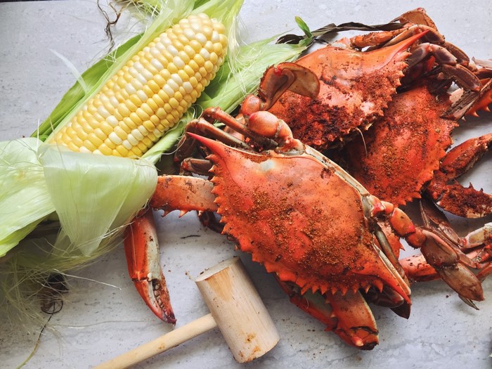 Steamed crabs and corn on the cob with a mallet