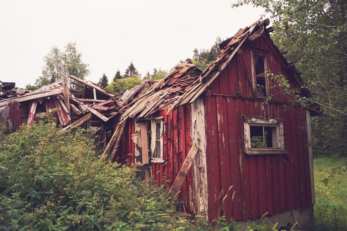 Dilapidated red wooden building in a rural area