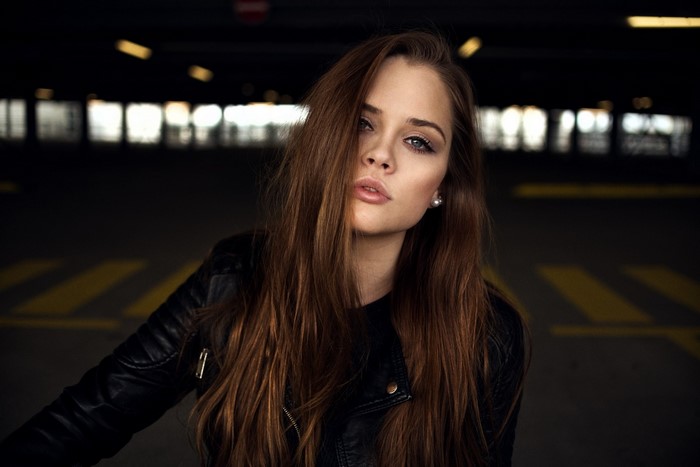 Woman with long brown hair wearing a leather jacket