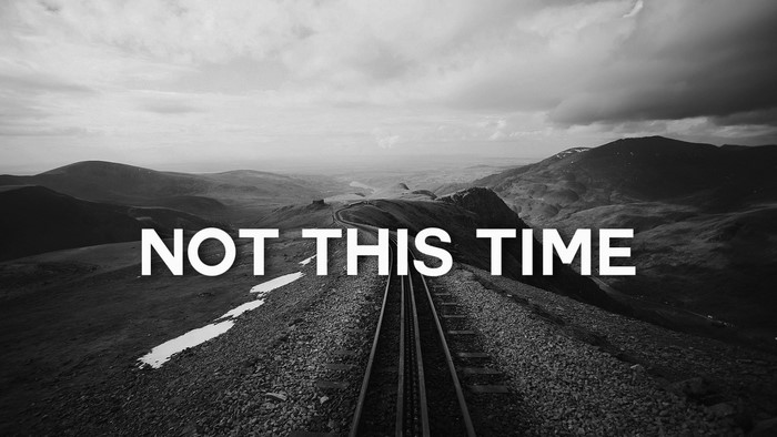NOT THIS TIME text on mountain landscape with train tracks
