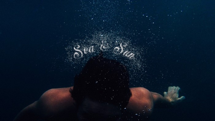 Man swimming underwater with "Sea & Sun" text