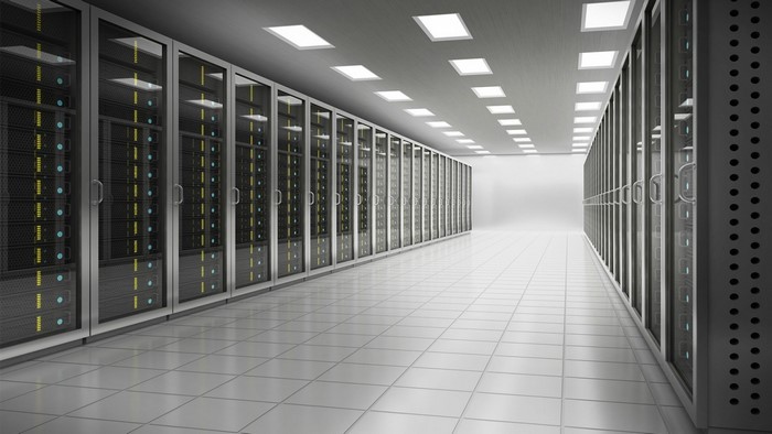 Server room with rows of data racks and ceiling lights