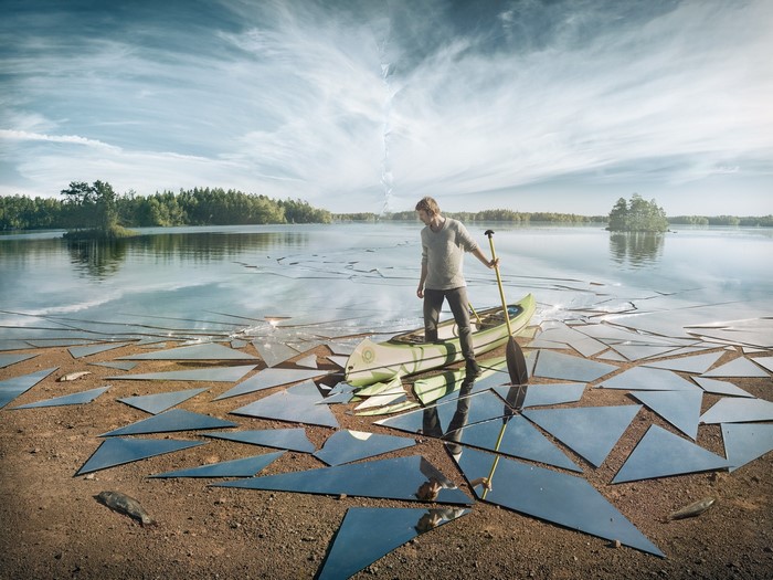 Man Standing on Canoe Amidst Shattered Glass Illusion