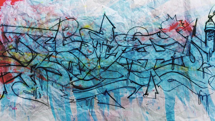 Graffiti art with blue and red spray paint on crumpled paper