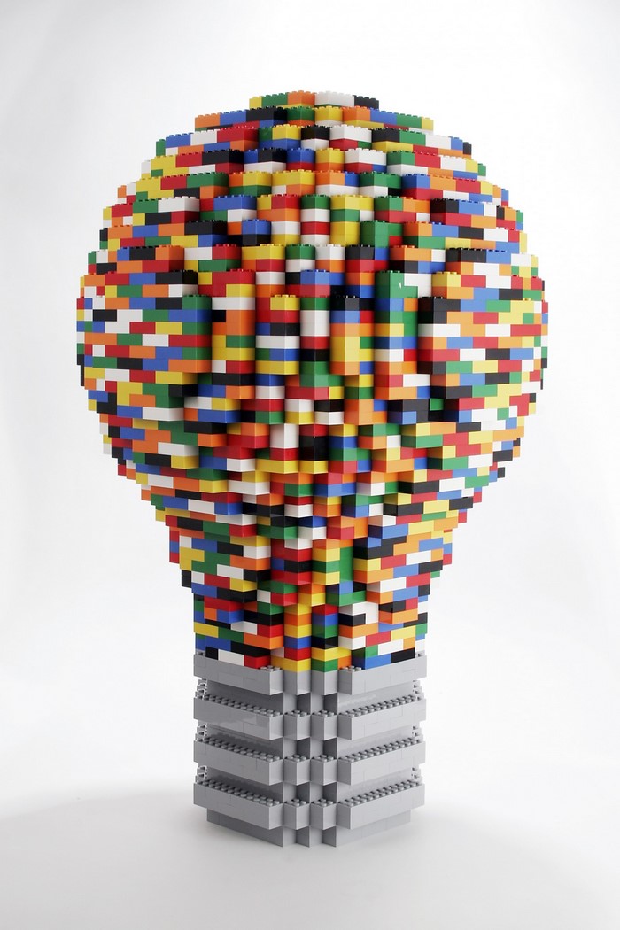 Colorful LEGO lightbulb sculpture on white background