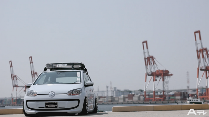 White Volkswagen Up with Thule roof rack at a harbor