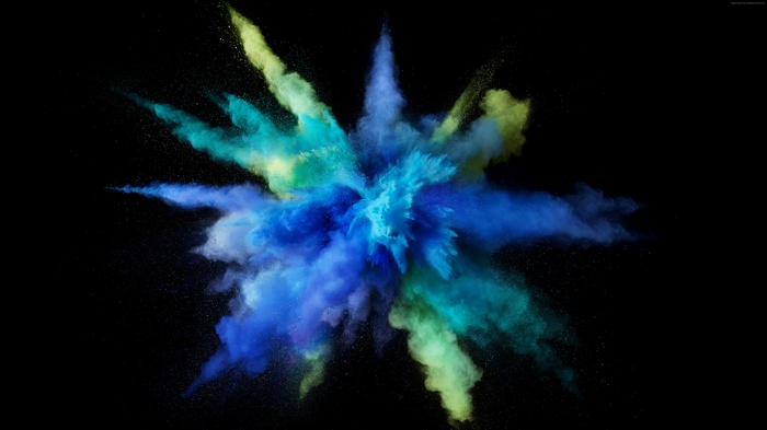 Explosion of blue, green, and yellow powder