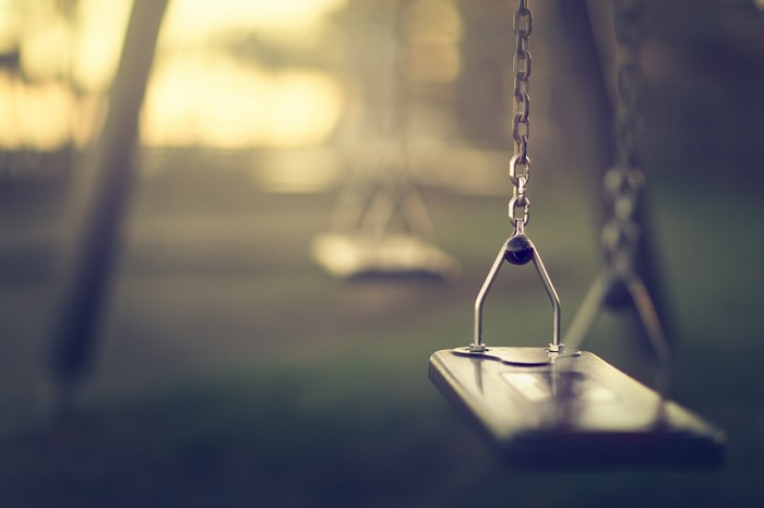 Empty swingset in a park at sunset