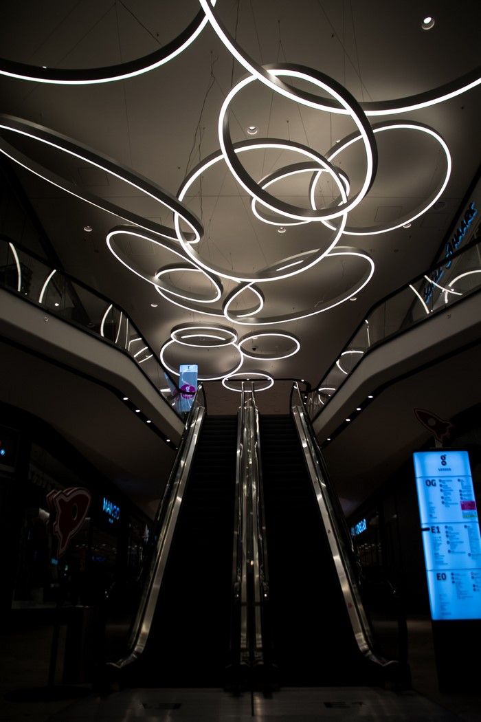Modern Shopping Mall Interior with Escalators and Ring Lights