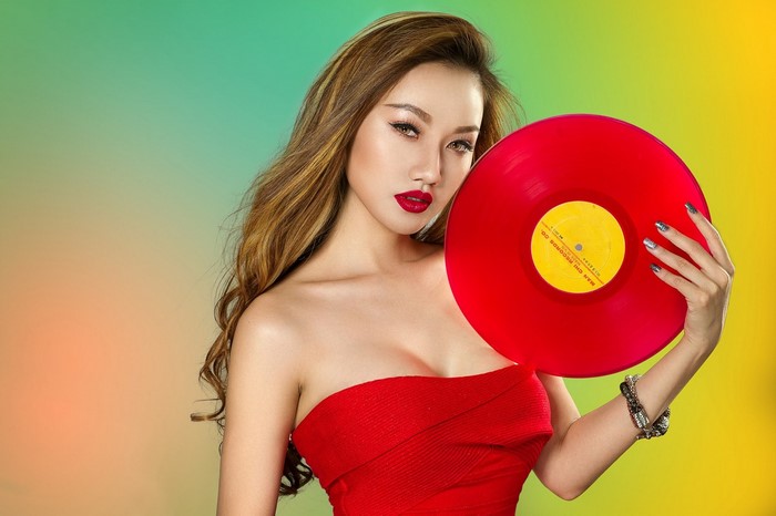 Woman in red dress holding a red vinyl record