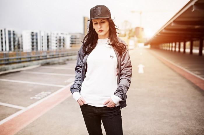 Woman wearing a bomber jacket and baseball cap