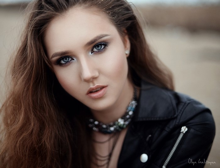 Portrait of a woman with long brown hair and makeup