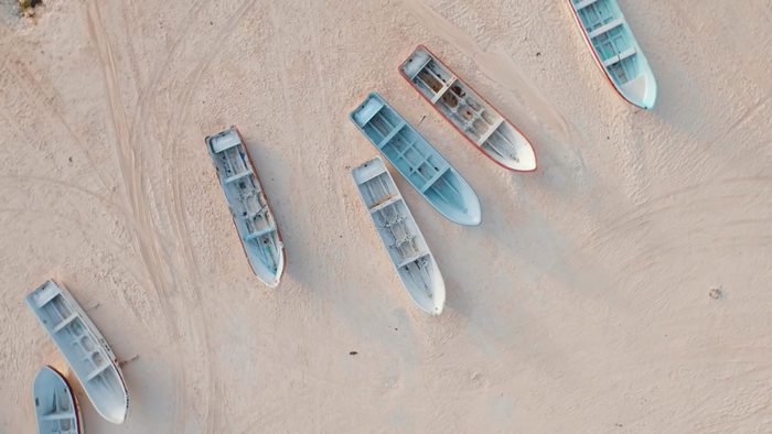 Several boats resting on a sandy beach