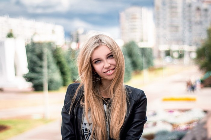 Woman with long blonde hair wearing a black jacket