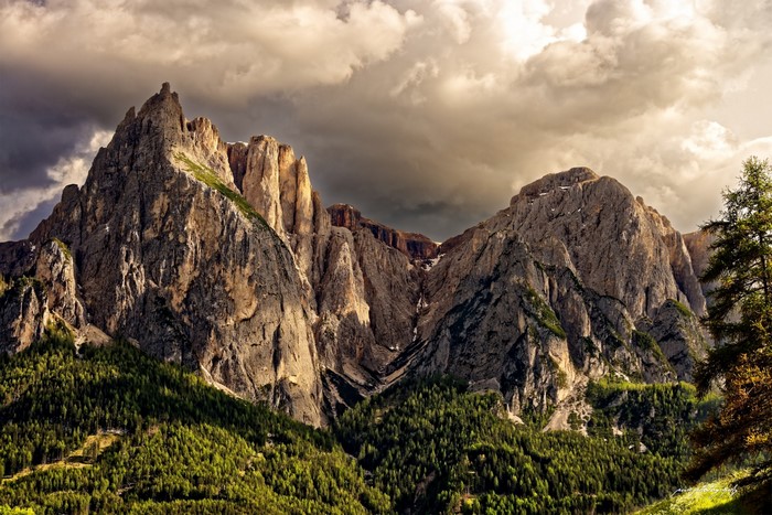 Dramatic mountain range with dramatic clouds and trees
