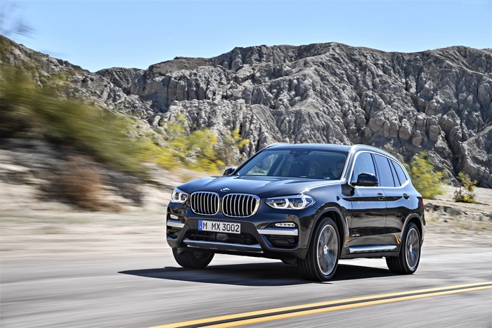 BMW X3 driving on a desert road