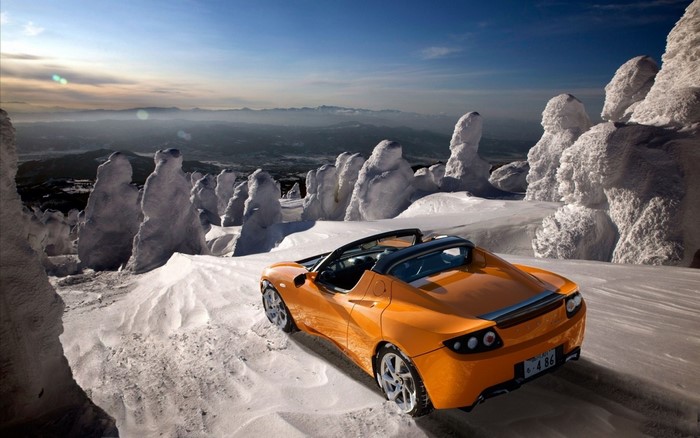 Orange Tesla Roadster in Snowy Mountains