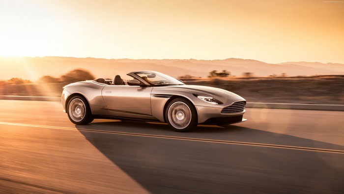Aston Martin DB11 Volante convertible driving at sunset