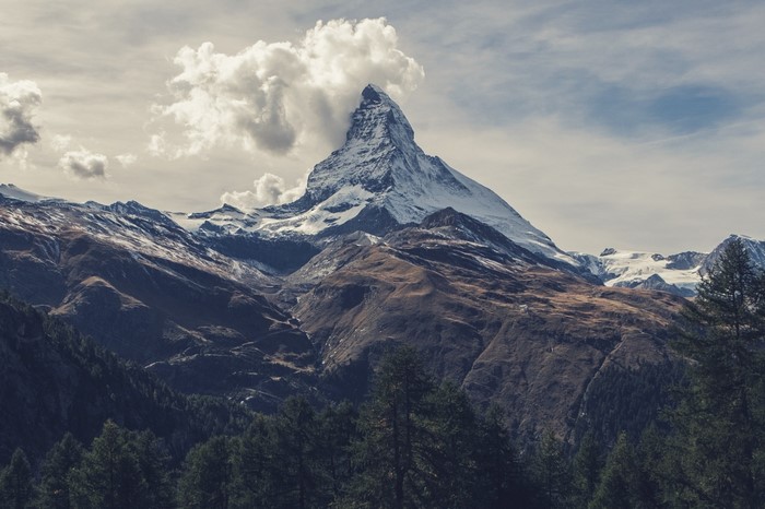 Matterhorn mountain peak with clouds and forest