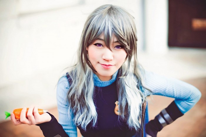 Woman in Zootopia cosplay holding a carrot pen