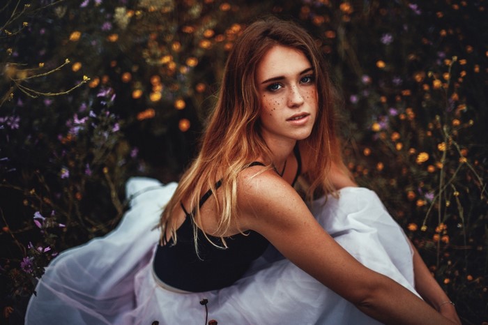 Woman with freckles in a field of flowers