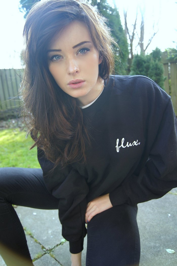 Woman with long brown hair wearing a black sweatshirt