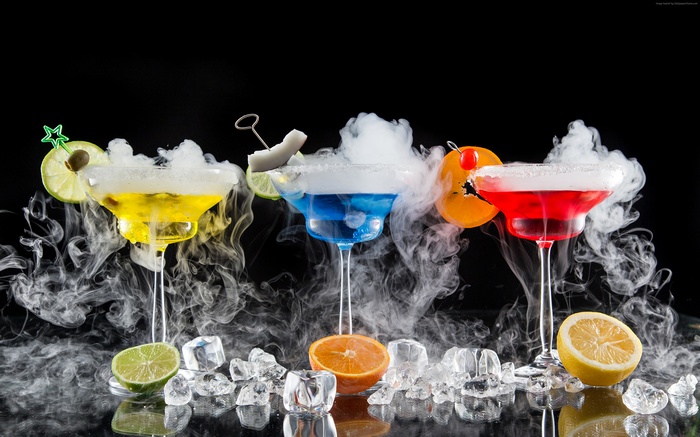 Three colorful cocktails with smoke and fruit