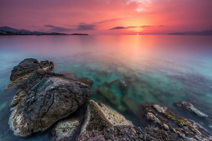 Sunset over the sea with rocks in the foreground